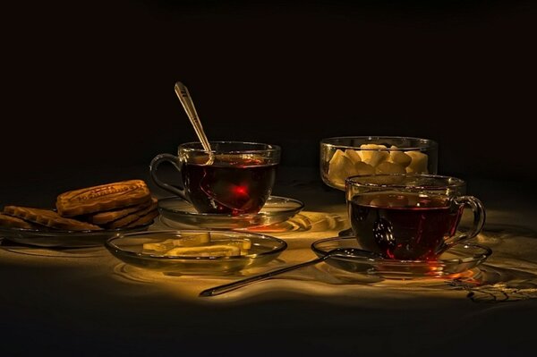 Cups with tea , lemon and sweets