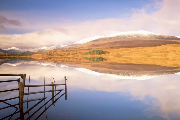 The lake reflects the mountains and the sky