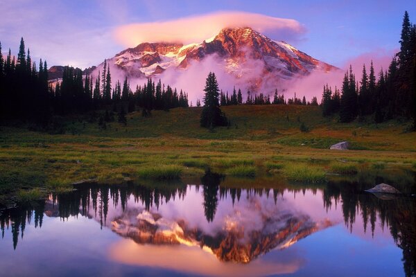Reflection in the lake of a large mountain with clouds