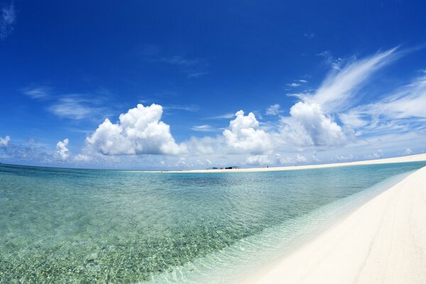A beach with white sand and clear water