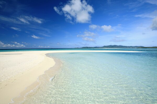 A beach with white sand and clear water