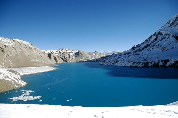 Der Bergsee ist mit Schnee bedeckt