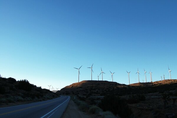 The road passes by white windmills