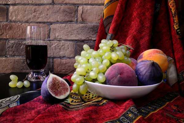 A plate of fruit and a glass of wine