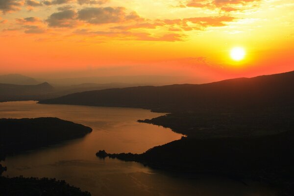 Fiume ai raggi del sole in uscita nuvole sullo sfondo del tramonto