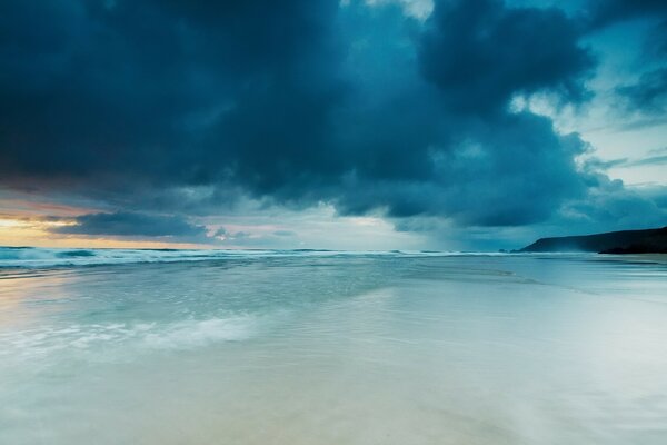 Blue, undulating sea and blue clouds