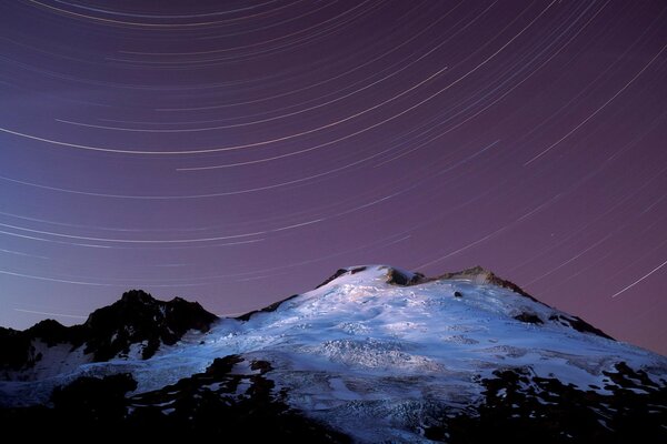 Montagna innevata con cielo stellato