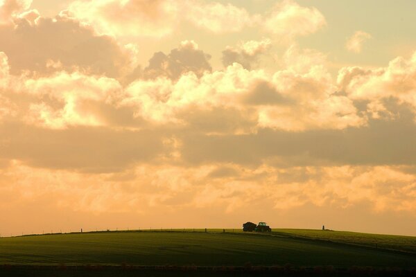 Traktor im Feld vor dem Hintergrund der Wolken