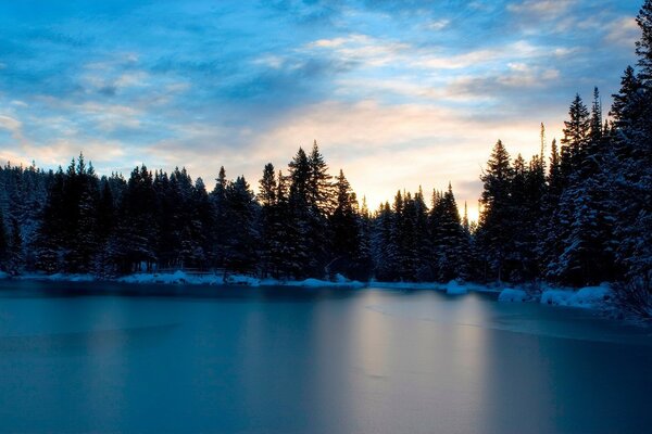 Озеро зимой , окружённое лесом