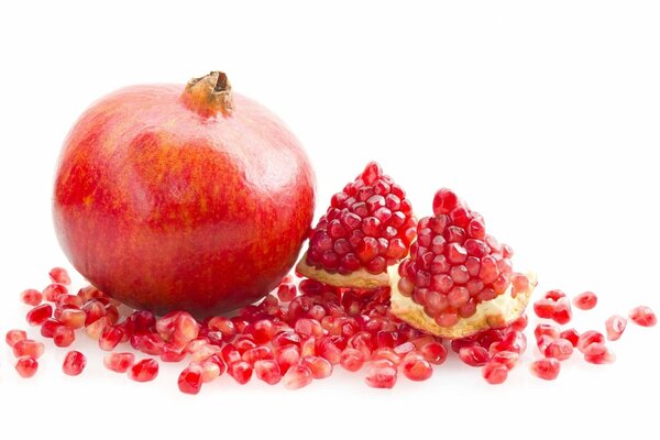 Pomegranate and its grains on a white background