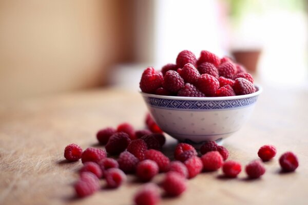 Himbeerbeeren in einem Teller auf einem Holztisch