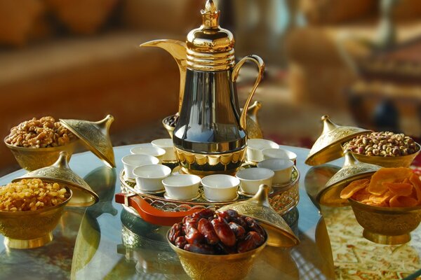 There is a set of cups and a teapot on the table