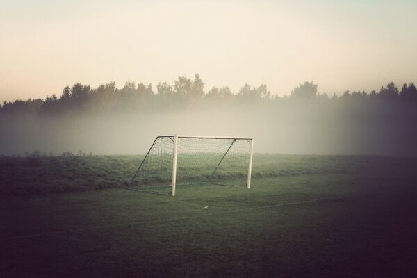 Тупанное футбольное поле, футбольное поле утром, футбольные ворота в тумане