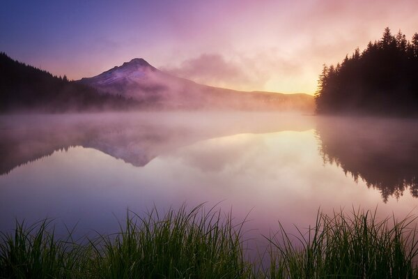 Montagnes, brouillard et lac tranquille