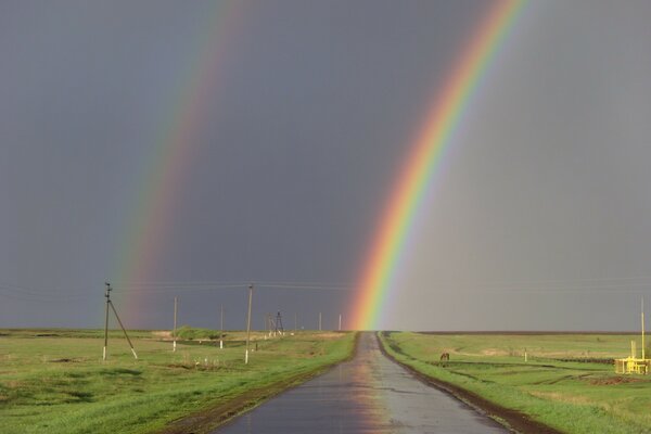 Двойная радуга на дороге в поле