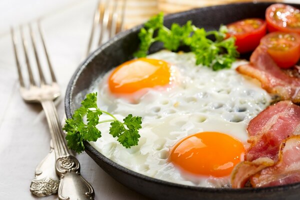 Scrambled eggs with bacon and herbs and tomatoes