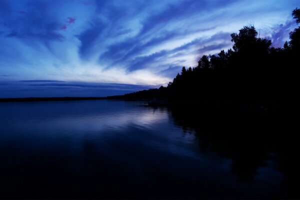 Облачный вечер на синем озере