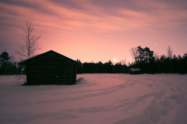 Одинокий дом среди снежного пейзажа на закате