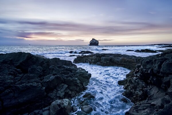 Pierres noires et mer bleue