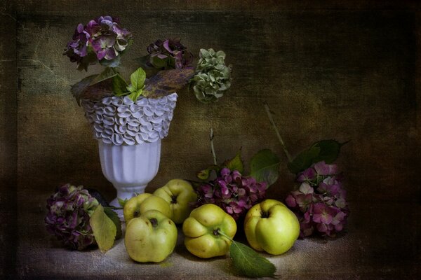 Mele con fiori in un vaso sul tavolo