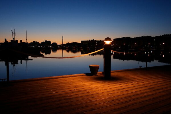 Lanterne rougeoyante sur le quai de nuit