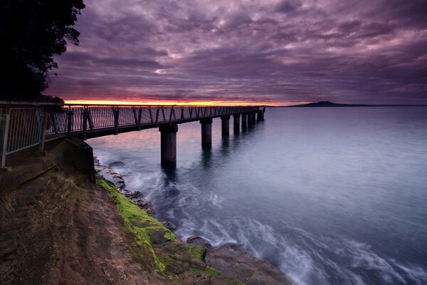 Purple sky. Berth on the shore of the blue sea