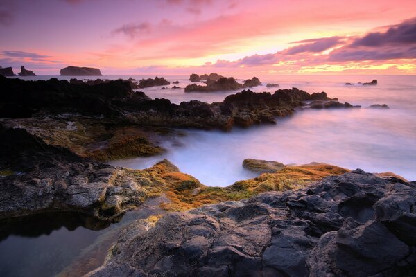 Puesta de sol sobre las montañas brumosas junto al mar