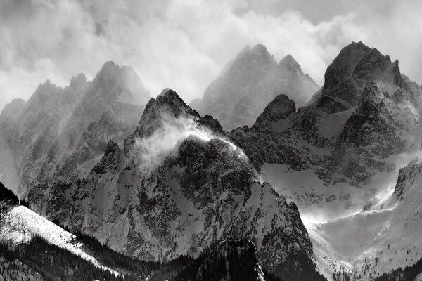 Image en noir et blanc des montagnes enneigées et des nuages