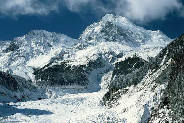 Paisaje de montaña. Montañas cubiertas de nieve contra el cielo azul