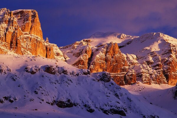 Montagne nella neve su uno sfondo di cielo blu