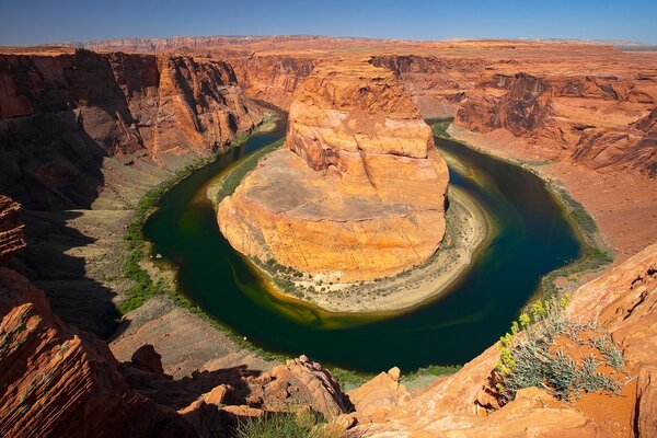 Anello di acqua scura intorno alla roccia nel canyon