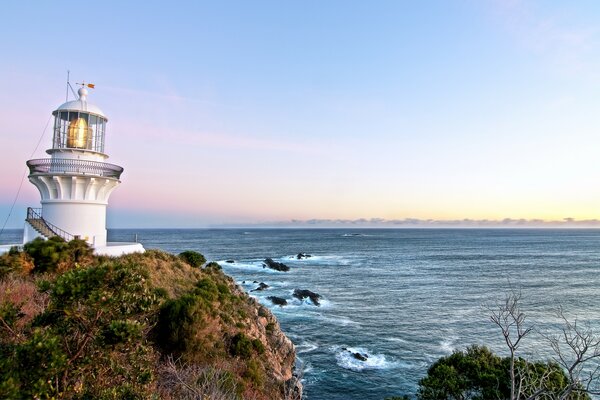 Faro en la orilla del mar al amanecer