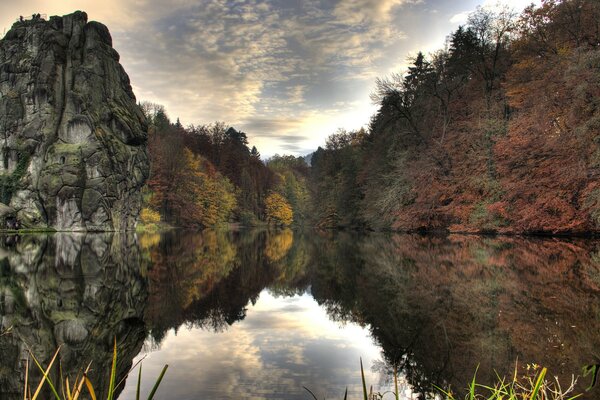 La tranquila superficie del lago en el bosque de otoño