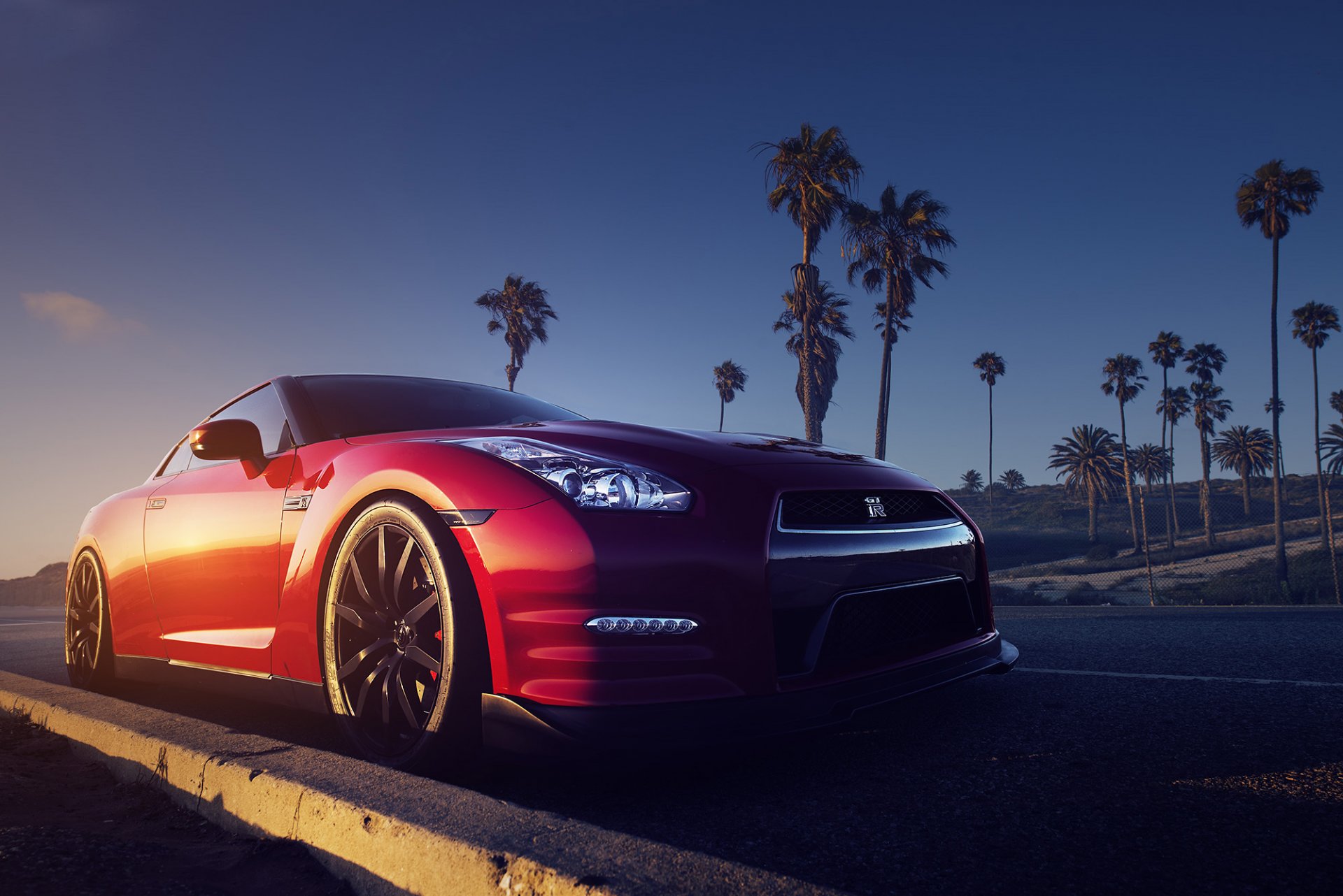 nissan gt-r r35 rosso anteriore strada palme tramonto