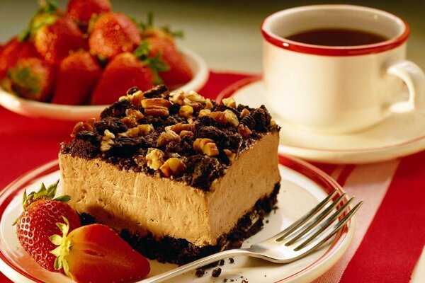 A piece of cake with nuts and strawberries on a plate