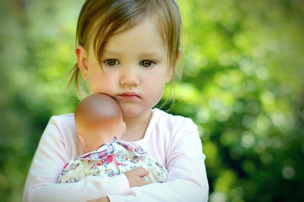 A little girl hugs a doll