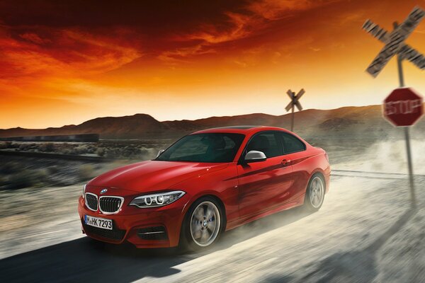Red BMW car on sunset background