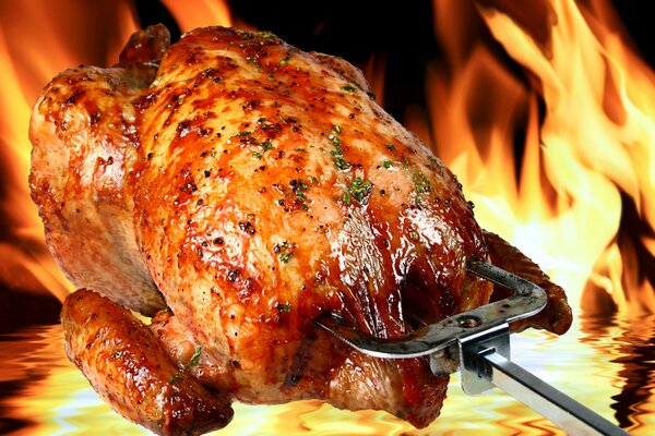 Grilled chicken with a crust on the background of fire