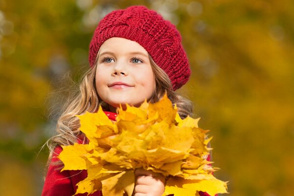 Mädchen in einer roten Barett mit einem Herbststrauß