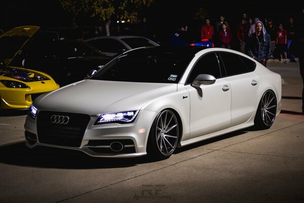 Audi blanco con tintado y faros encendidos