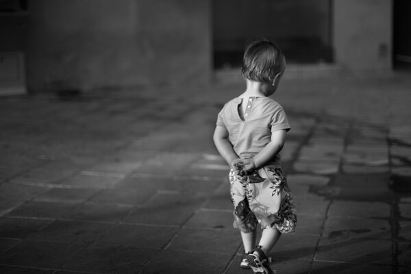 Czarno-białe zdjęcie chłopca na ulicy