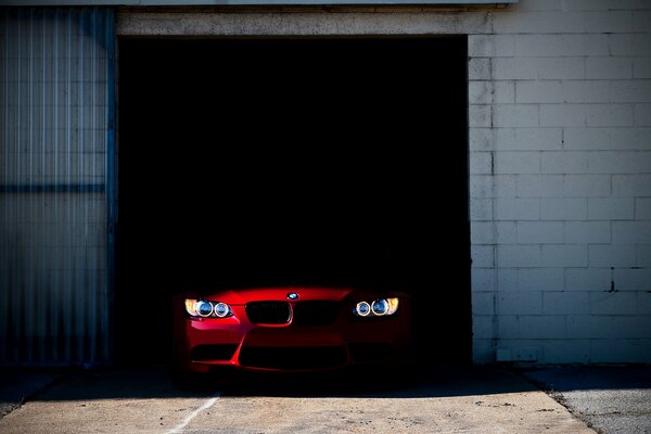 Czerwone BMW wyjeżdża z garażu