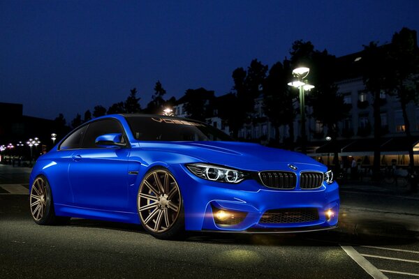 Blue BMW 4 series . Front view in the night city