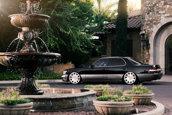 A black car on the background of a fountain