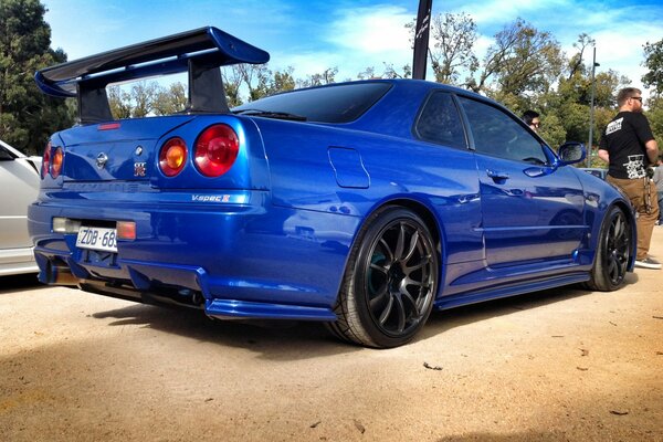 Blue Nissan with tuning on the background of sand and sky