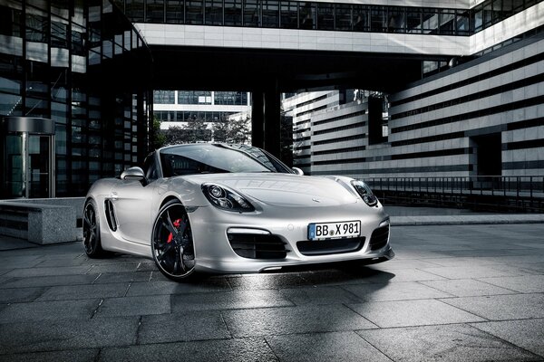 Une Porsche argentée se dresse sur le bâtiment