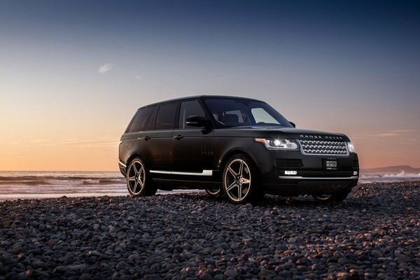 Jeep noire près de la rivière au coucher du soleil