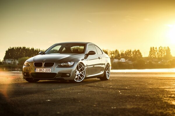 BMW gris en una puesta de sol dorada