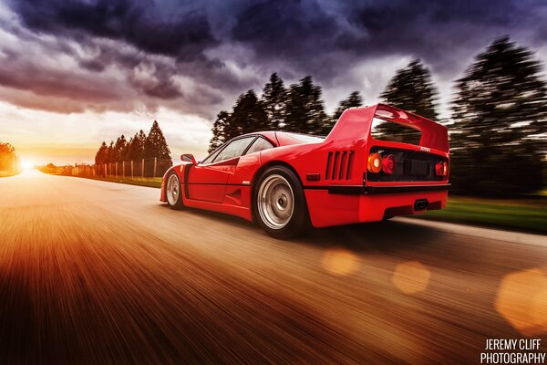 A red Ferrari is racing down the road