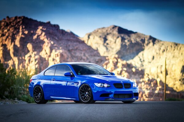 Blauer BMW bei Tageslicht in den Bergen